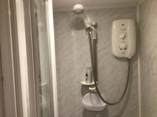 a shower in a bathroom next to a toilet at Lovely studio apartment near camborne in Camborne