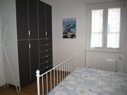 a bedroom with a large black cabinet next to a bed at Casa Casella, delizioso bilocale a due passi dal mare in Lido di Ostia