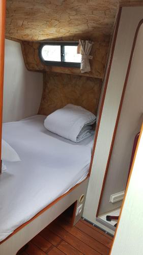 a small bedroom with a bed in a tiny house at Bateau 6 personnes sans permis terrasse à quai ou option navigation in Béziers