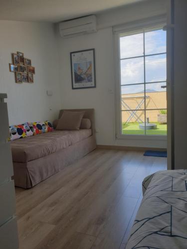 un salon avec un canapé et une grande fenêtre dans l'établissement Superbe appartement 2 chambres piscine et plage, à Gassin