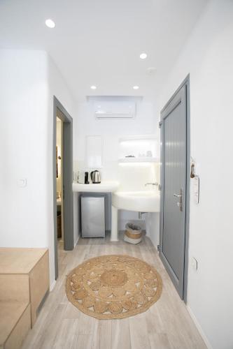 a white room with a door and a rug at Majestique of Naxos in Naxos Chora