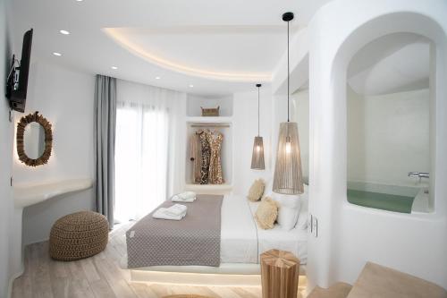 a white bedroom with a bed and a mirror at Majestique of Naxos in Naxos Chora