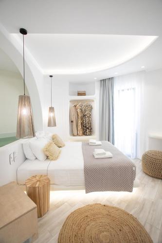 a white bedroom with a large bed and a couch at Majestique of Naxos in Naxos Chora
