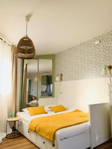 a bedroom with a bed with yellow sheets and a mirror at La Casita del Patio in Santiago de Compostela