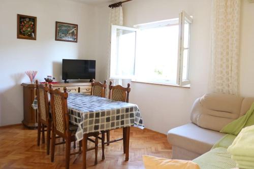 a living room with a table and chairs and a couch at Olive apartments in Grebaštica