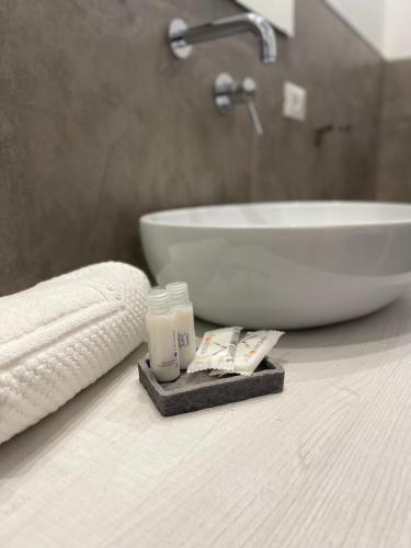 a bathroom counter with a sink and a bottle of soap at Minioto Rooms in Noto