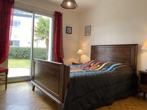ein Schlafzimmer mit einem Bett und einem großen Fenster in der Unterkunft Maison Étel, 4 pièces, 6 personnes - FR-1-397-20 in Étel