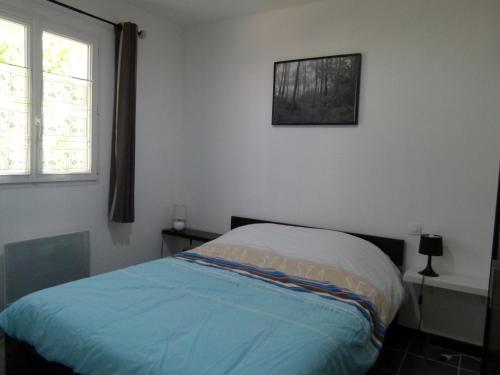 a bedroom with a bed and a picture on the wall at Maison neuve à Jard-sur-Mer, proche plage, forêt, port, 4 pers, WiFi, jardin, plancha - FR-1-336-59 in Jard-sur-Mer