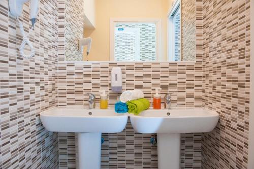 a bathroom with two sinks and a mirror at Budget Rooms Des Arts in Rome