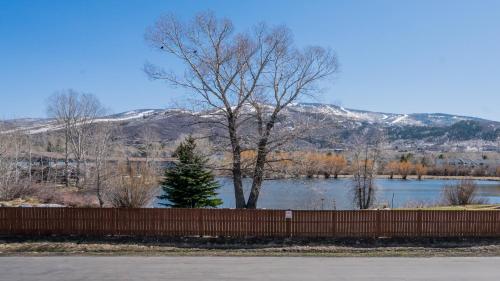 a tree sitting behind a fence next to a lake at Holiday Inn Steamboat Springs by IHG in Steamboat Springs
