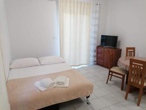 1 dormitorio con 1 cama con toallas en Apartments Dinko, en Duće