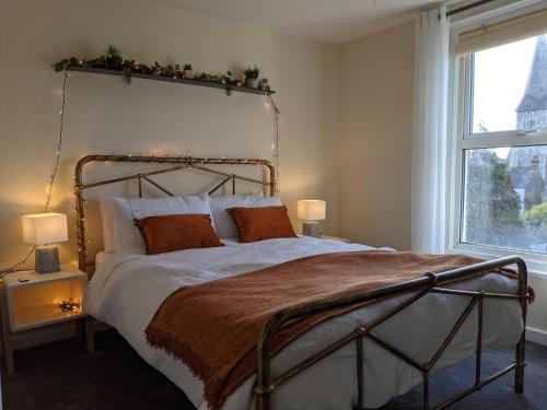 a bedroom with a large bed and a window at Stylish penthouse apartment in Ramsgate