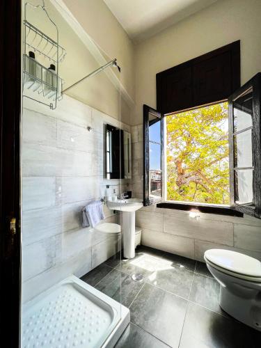 a bathroom with a toilet and a sink and a window at Villa Nestor in Ingenio