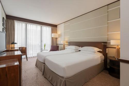 a hotel room with a large bed and a desk at Terra Nostra Garden Hotel in Furnas