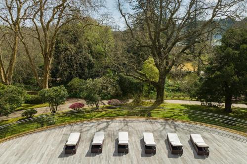 a group of white benches in a park at Terra Nostra Garden Hotel in Furnas