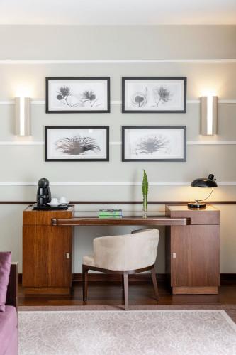 a desk in a living room with three pictures on the wall at Terra Nostra Garden Hotel in Furnas