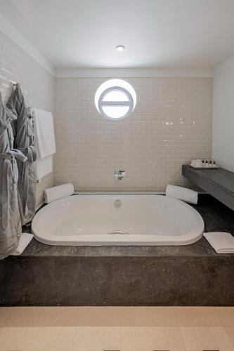 a large bath tub in a bathroom with a window at Terra Nostra Garden Hotel in Furnas