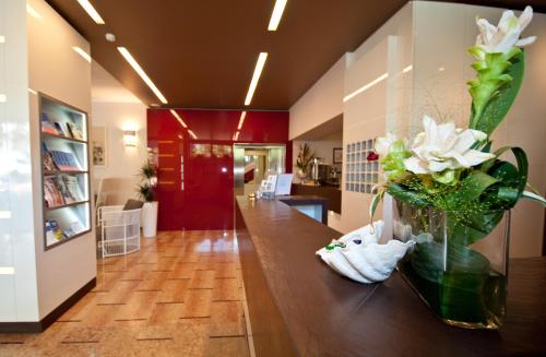 un couloir avec un vase de fleurs sur une table dans l'établissement Hotel Park Spiaggia, à Grado