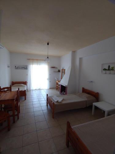a living room with two beds and a table at Milios Studios in Megálon Choríon