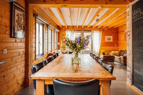 jadalnia z drewnianym stołem i krzesłami w obiekcie Ride by the Sea Guesthouse w mieście Koudekerke