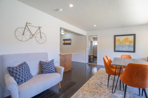 a living room with a table and a bike on the wall at Spacious 4 bedroom house close to everything! in Salida