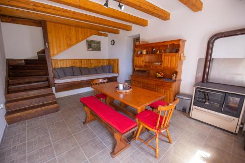 a dining room with a table and chairs and a stove at Mountain House VENI in Jablanac