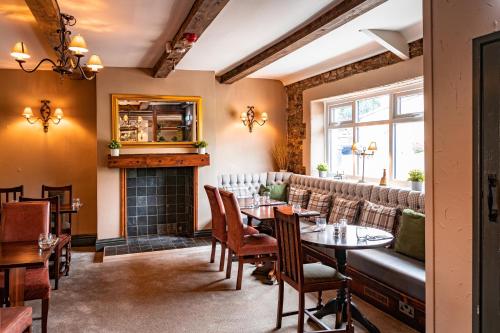 a restaurant with tables and chairs and a fireplace at The Derwent Arms in Edmondbyers