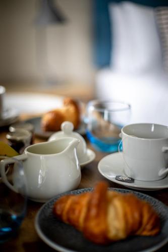 a table with two cups and a croissant and coffee cups at Sail Lofts in Douglas