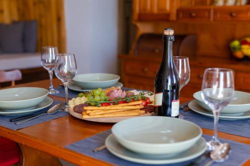 Mountain House VENI في جابلاناك: طاولة مع زجاجة من النبيذ وصحن من الطعام