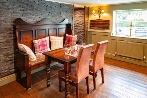 a dining room with a wooden table and chairs at The Derwent Arms in Edmondbyers