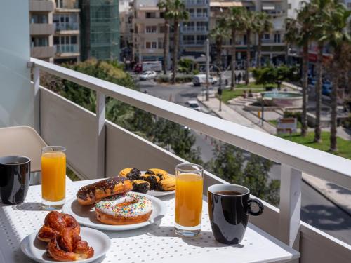 a table with two plates of donuts and orange juice at Electra Luxury Apartment at the Heraklion Center in Heraklio Town