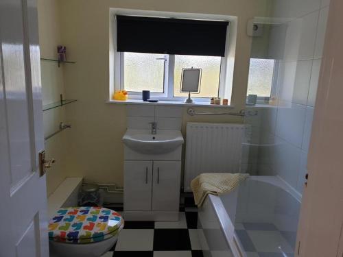 baño con lavabo y aseo y ventana en Yew Tree Bungalow, Onneley, Cheshire, en Crewe