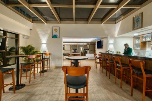 a bar in a restaurant with wooden tables and chairs at Kibo Palace Hotel Moshi in Moshi