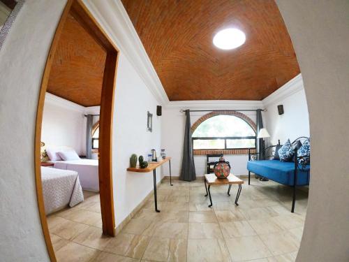 a living room with a blue couch and a bedroom at Hacienda San Patricio in San Miguel de Allende