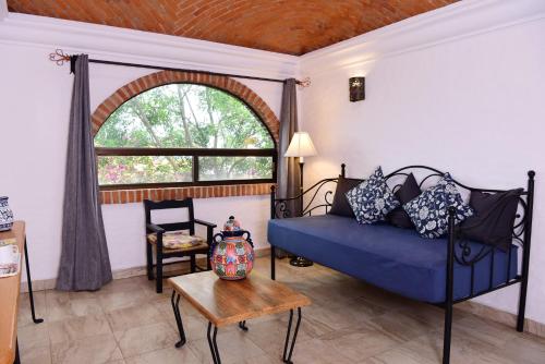 a living room with a blue couch and a window at Hacienda San Patricio in San Miguel de Allende