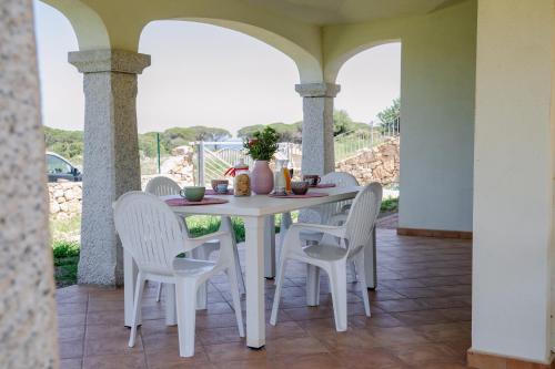 einen weißen Tisch und Stühle auf einer Terrasse in der Unterkunft Residenze Pedrame in Budoni