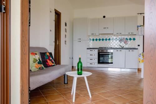 a living room with a table and a wine bottle at Residenze Pedrame in Budoni