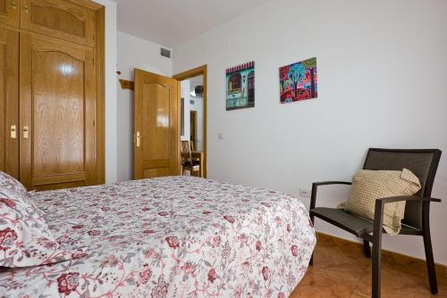 a bedroom with a bed and a chair at Relaxing Beach Apartment in Fuengirola AC&WIFI in Fuengirola