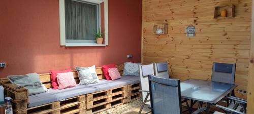 a bench in a room with chairs and a window at Tavi Panzió in Dunapataj