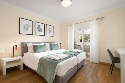 1 dormitorio con 1 cama blanca grande y escritorio en Light and Modern - On-site Pool and Restaurant - Cabanas de Tavira en Cabanas de Tavira