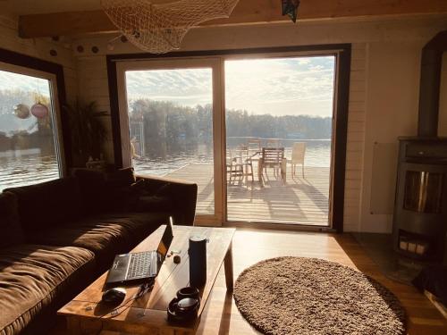 een woonkamer met een bank en een tafel met een laptop bij Großes gemütliches Hausboot in Berlin in Berlijn