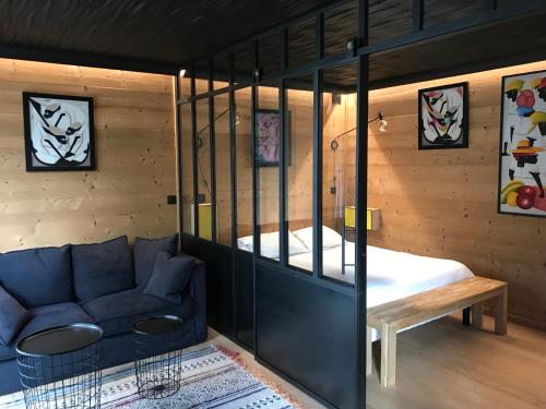 a living room with a couch and a bed at les suites de bach in Ploemeur
