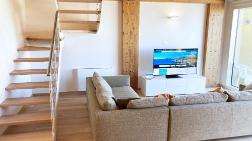 un salon avec un canapé et une télévision dans l'établissement Fronte Mare Suites - ArgonautiVacanze, à Portoferraio