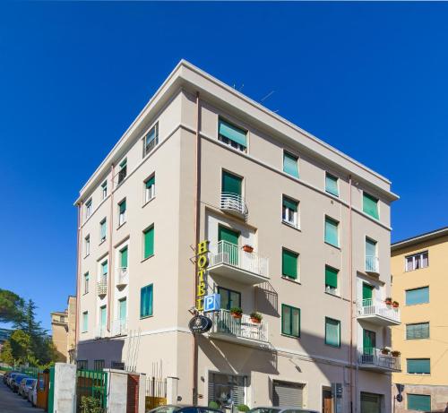 a tall white building with green windows at Hotel Maria in Pisa