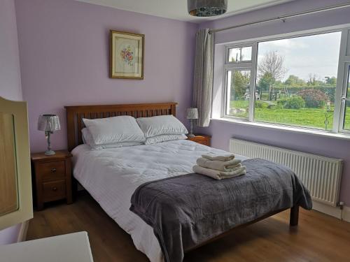 ein Schlafzimmer mit einem Bett und zwei Handtüchern auf einem Tisch in der Unterkunft Brownstead Cottage in Navan