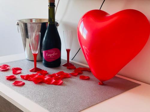 a red heart next to a bottle of wine and glasses at B&B Marrelli Crotone in Crotone