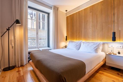 a bedroom with a large bed and a window at Tempo FLH Hotels Lisboa in Lisbon