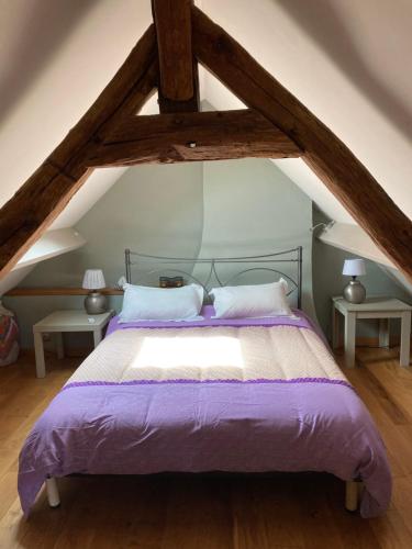 - une chambre avec un lit doté de draps et d'oreillers violets dans l'établissement La duvallerie chambre d hôte, à Cangey