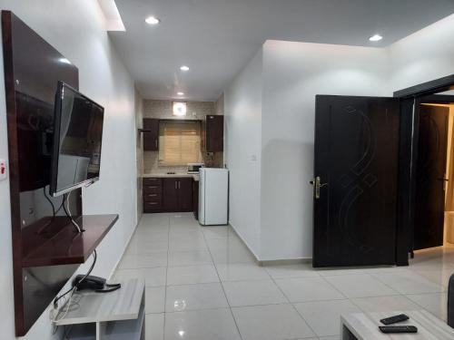 uma cozinha com uma porta preta e um frigorífico em قرنيت الطائف للشقق المخدومة em Taif