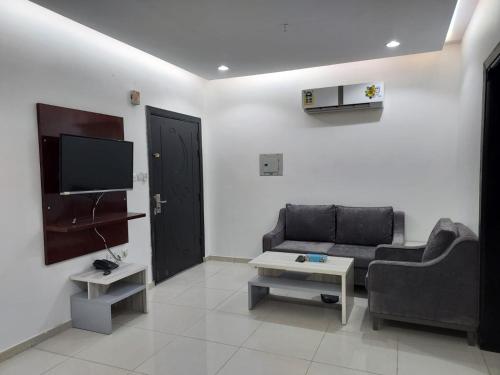 a living room with a couch and a tv at قرنيت الطائف للشقق المخدومة in Taif
